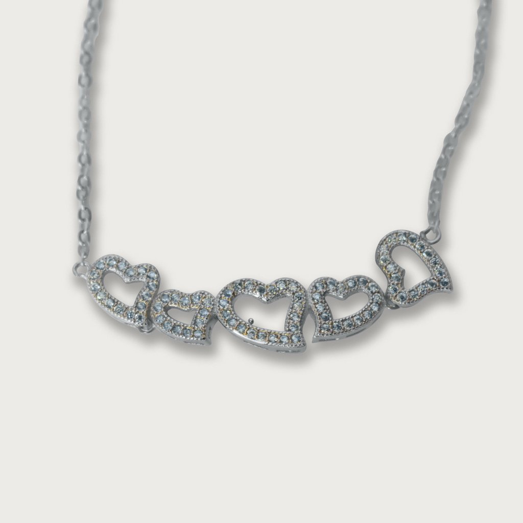 Brazalete de plata italiana con baño de rodio, adornado con corazones y piedras preciosas, un diseño elegante y sofisticado.