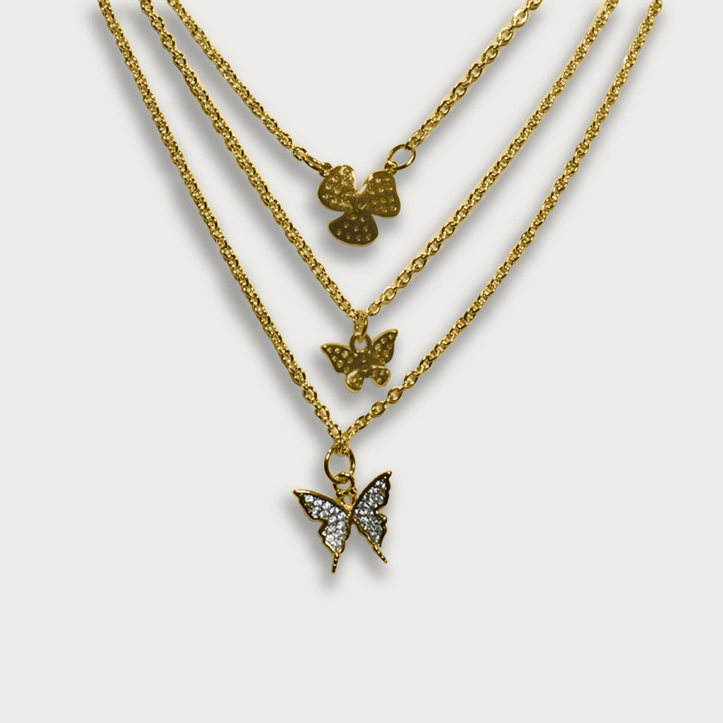 Collar triple de chapa de oro de 18K con dijes de mariposas y flor, diseño elegante y moderno en capas.